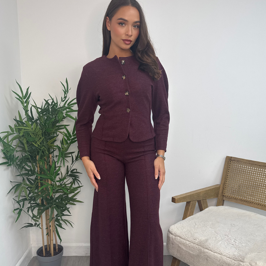 Wholesale women’s knit co-ord sets being worn by model in burgundy, button-up top and wide-leg trouser matching sets from AW25 wholesale collection for retail buyers.