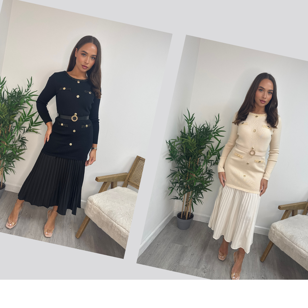 Wholesale women’s pleated knit midi dresses in black and cream worn by model. Long sleeve button-detail dresses with belted waist from the AW25 wholesale clothing collection for retail buyers