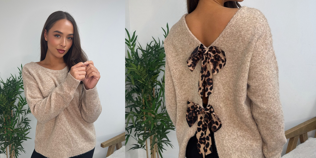 Wholesale women’s beige knit jumper with leopard print bow back detail worn by model. Soft brushed texture long sleeve sweater from AW25 wholesale collection for retail buyers